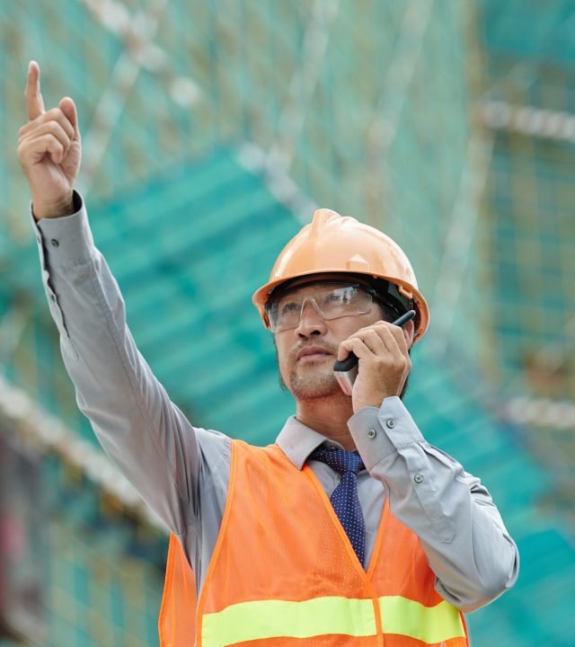 Supervisor managing building process with the help of walki-talkie